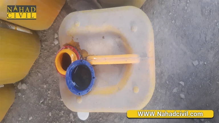 کارشناس آزمایشگاه در حال نمونه‌برداری از افزودنی شیمیایی بتن در کارخانه تولید قطعات بتنی پیش‌ساخته